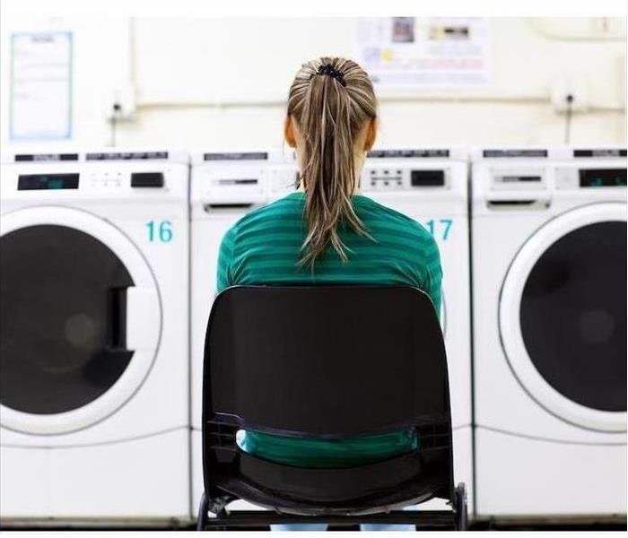 Person Sitting In a Chair At a Laundromat